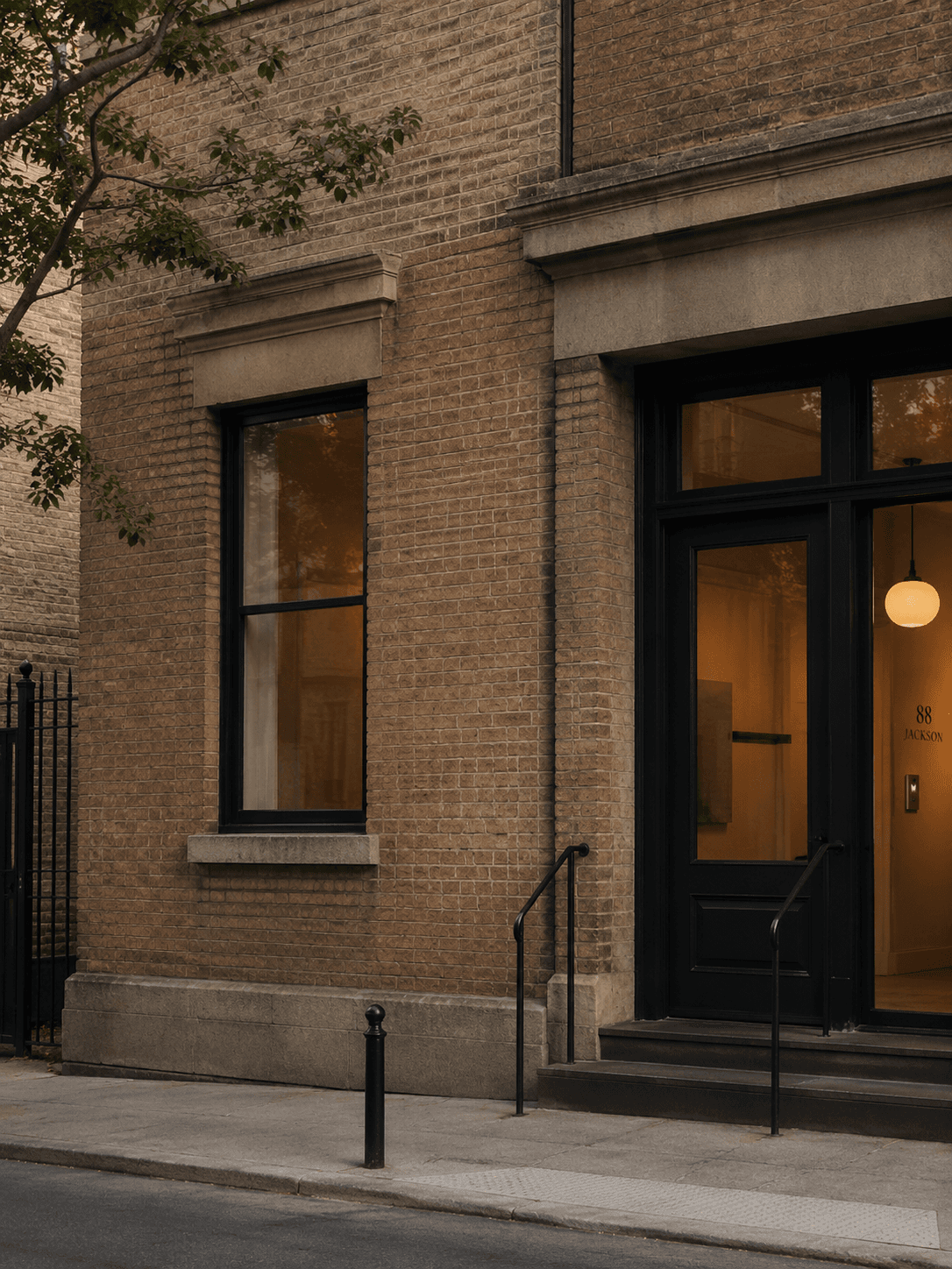 Historic corner entrance with dark trim, brick surround, and warm interior lighting